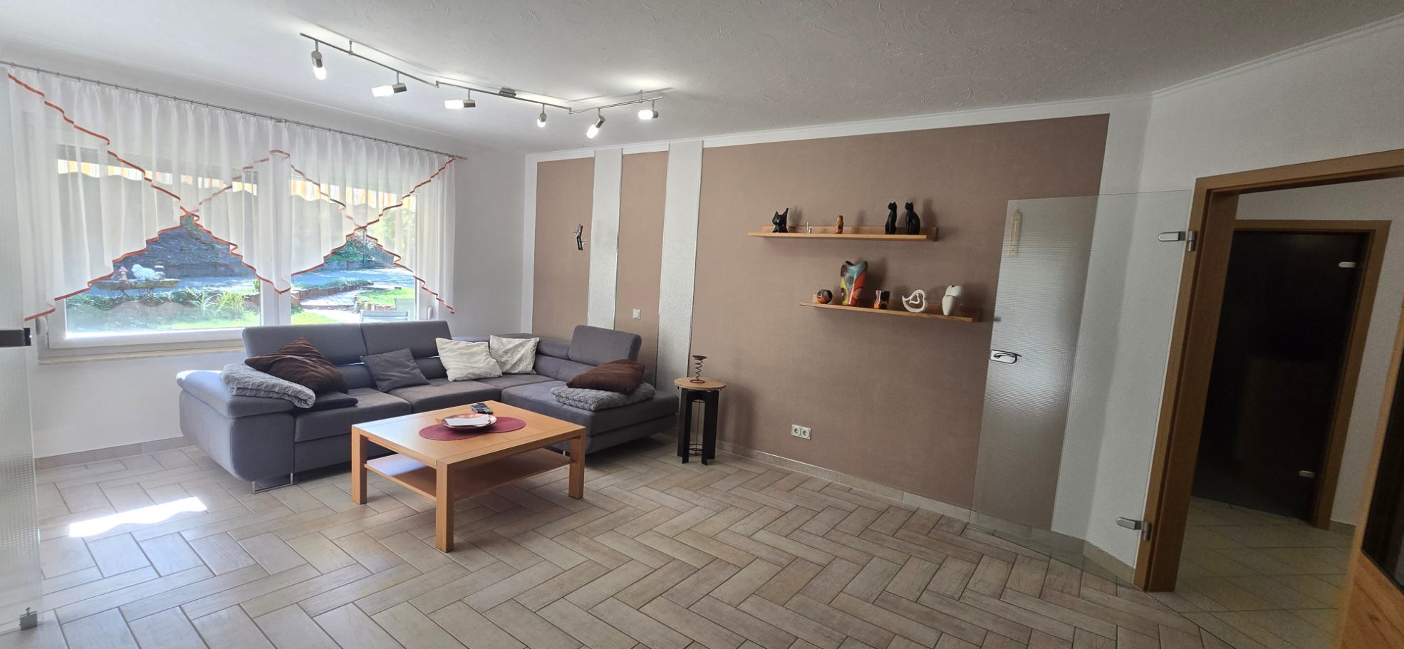 Großes gemütliches Wohnzimmer Wohnzimmer mit großer Fensterfront im Hintergrund